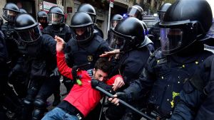 En av demonstranterna som revs bort av kravallpolis i närheten av den spanska regeringens kontor i Barcelona under söndagens demonstrationer.