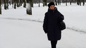 Zoja Jefimova på promenad i en snöig park är jättenöjd med sin hemstad. Zoja Jefimova på promenad i en snöig park.