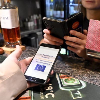 Tarjoilija tarkistaa asiakkaan koronapassia One Pint Pubin baaritiskillä Ruoholahdessa, Helsingissä.