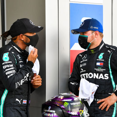 Lewis Hamilton och Valtteri Bottas står och talar med varandra.