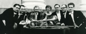 Leoš Janáčekin Capriccion vasemmalle kädelle ja puhallinyhtyeelle esittivät (vas.) cornisti Holger Fransman, huilisti Pertti Rasilainen, trumpetistit Jalo Nuutinen ja Lauri Ojala, pianisti Meri Louhos, pasunistit Olavi Lampinen ja Jaakko Muurimäki sekä cornisti Antero Kasper. Suomalaisten puhaltajien kanssa Meri esitti Helsingin kaupunginorkesterin konsertissa Janacekin Capriccioson Vasemmalle kädelle ja puhaltajille.