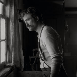 Saknar Ephraim (Robert Pattinson) sitt tidigare jobb som skogshuggare? Havet förstår han sig inte på. Ephraim (Robert Pattinson) står vid ett fönster och ser ut.