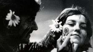1960-talets hippierörelse var en form av aktivism. En hippieman målar en blomma på en hippikvinnas kind