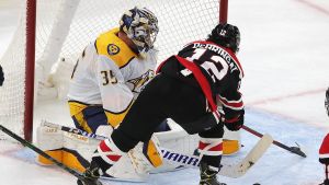 Chicagos Alex DeBrincat petar in 2–2-pucken bakom Pekka Rinne i Nashvilles mål. Chicagos Alex DeBrincat petar in 2–2-pucken bakom Pekka Rinne i Nashvilles mål.