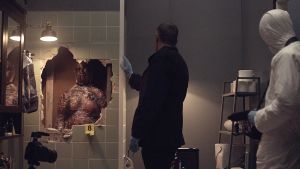 Sorjonen (Ville Virtanen) tutkii kylpyhuoneen seinän sisälle piilotettua ruumista.
