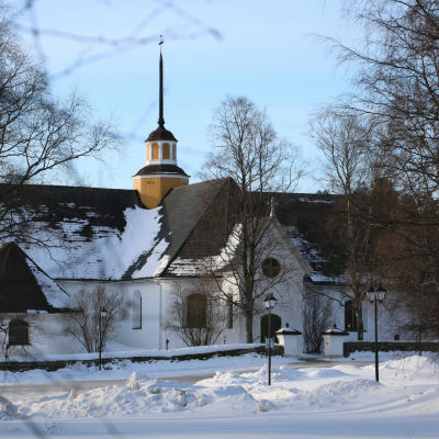 En vit kyrka med svart tak.