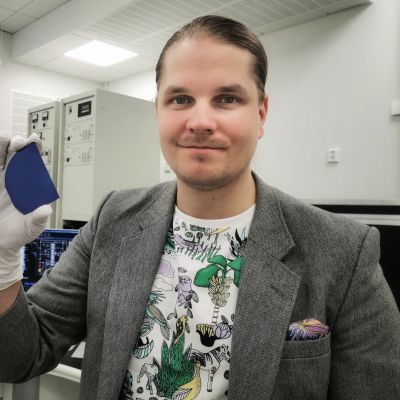Erkka Frankberg pitää kädessään plastista lasia