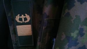 Kyrkan finns med också i det militära. militärprästens kors som tygmärke på militär rock