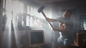 Docventuresin juontaja Riku Rantala rikkoo lekalla tietokoneen näytön.