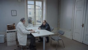 Det är synd om människan. Psykiatern och patienten. Psykiater och patient på varsin sida om ett bord.
