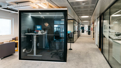 En person arbetar vid en dator i en liten officemodul.