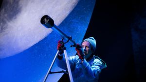 Rolle (Tobias Zilliacus) har ett livligt intresse för naturvetenskap och astronomi, vilket bara stämplar honom som en plugghäst. En man i mössa och vantar tittar i en stjärnkikare. I bakgrunden syns en väldig måne.