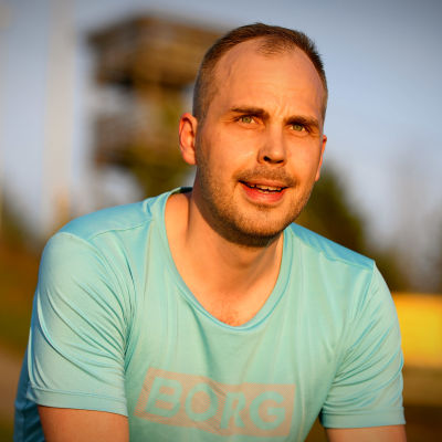 Martin Norrgård sitter på trapporna vid Öjberget i kvällssolen