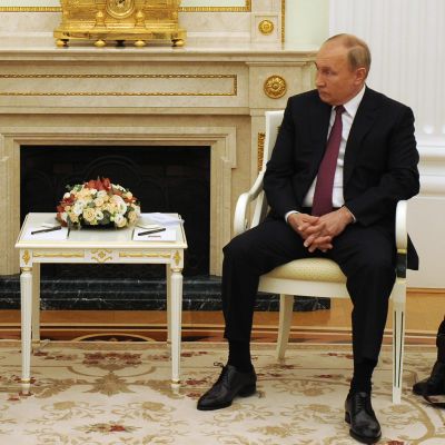 President Sauli niinistö och president vladimir Putin sitter på två stolar med en blomma emellan sig.