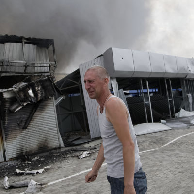 Man utanför sin förstörda affär i Donetsk.