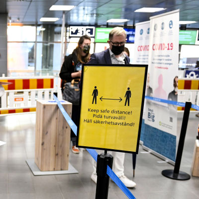 "Håll säkerhetsavstånd" står det på en skylt på Helsingfors-Vanda flygplats.
