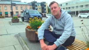 Arrangör Kristian Karnell vid Rådhustorget där det kommer att spelas bluesrock under lördagen. Kristian Karnell sitter på en bänk på Rådhustorget i Ekenäs.