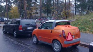 Den röda triangeln går ju att ta bort också, säger Sundqvist, så det finns en hel del att övervaka nog säger han. orange mopedbil so mstår parkerad bakom en personbil