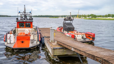 Två sjöräddningsbåtar ligger förtöjda vid en brygga.