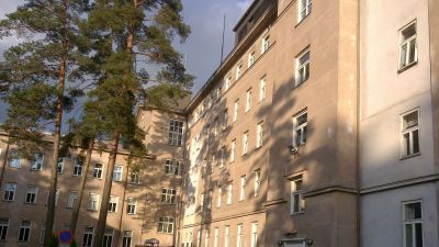 Baksidan av huvudbyggnaden vid Mjölbolsta sjukhus. En stor äldre stenbyggnad i 4-5 våningar.