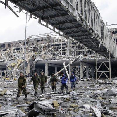 OSSE-observatörer och pro-ryska separatister vi den sönderbombade internationella flygplatsen i Donetsk.