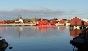 Utö är Finlands sydligaste ö. Hamnen i Utö med båthus och en lotskutter som speglas i vattnet.
