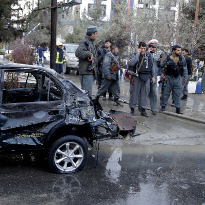 Säkerhetsstyrkor granskar en bil efter en själmordsbombares attack i Kabul.