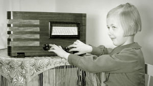 Pikkutyttö (Kirsti Nikulainen) kuuntelee radiota (1930-luku).