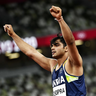 Neeraj Chopra jublar med båda händerna i luften.