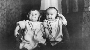 Kaksostyttövauvat kuuntelevat radiota kuulokkeilla 1920-luvun puolivälissä.