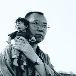 Liu Xiaobo tilldelades Nobels fredspris 2010. Svartbild bild på Liu Xiaobo som håller i en liten docka.