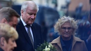 Inrikesminister Horst Seehofer med en stor bukett vita blommor i famnen vid minnesplatsen. Tysklands inrikesminister Horst Seehofer med en stor bukett rosor i famnen vid minnesplatsen i Hanau.