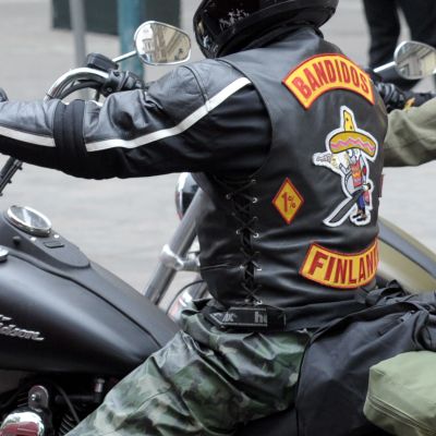 Bandidos moottoripyöräkerhon jäsen ajaa moottoripyörällä.