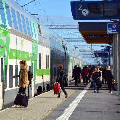 Folk går mot ett VR-tåg av typen Intercity på perrongen vid Bennäs tågstation