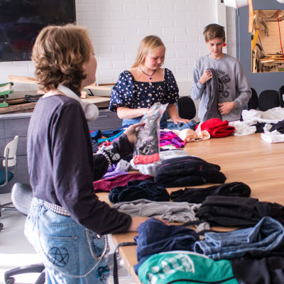 Tonåringar viker och sorterar kläder