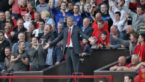 Arsène Wenger levittelee käsiään Manchester Unitedin kotistadionin Old Traffordin yleisön keskellä.