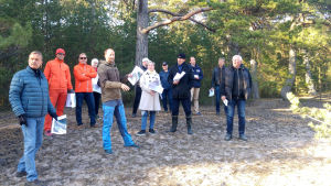 Stadsstyrelsen besökte Tullstranden tillsammans med Esko Tainio från Forststyrelsen. en grupp människor på strand nära skog
