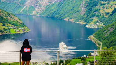 Människa som ser ut över en fjord.