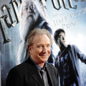 Alan Rickman och Harry Potter. Alan Rickman står framför en stor Harry Potter-plansch.