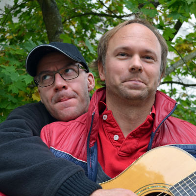 Marcus Granberg håller i gitarren medan Tomas Nyberg skojsamt spelar på den.