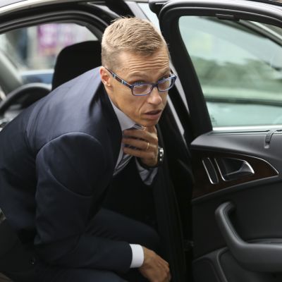 Alexander Stubb korjaa kravattiaan noustessaan auton takapenkiltä.