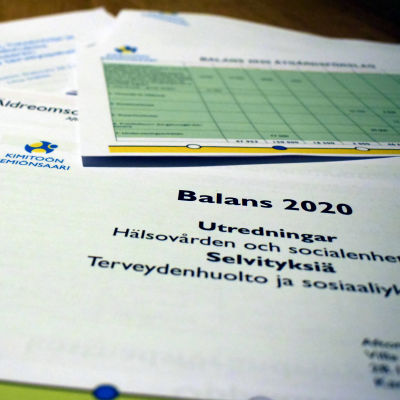En hög med utredningar där det står Balans 2020 på pappren.