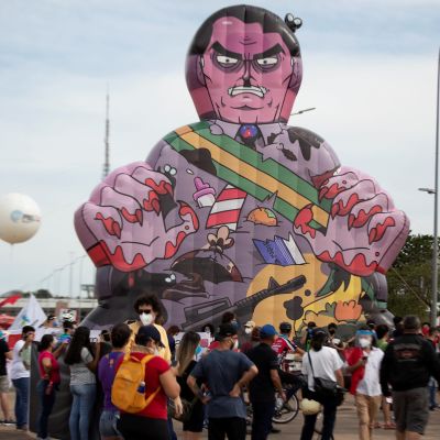Demonstration i Brasilien. Människosamling och en stor uppblåsbar figur som ska föreställa president Bolsonaro.