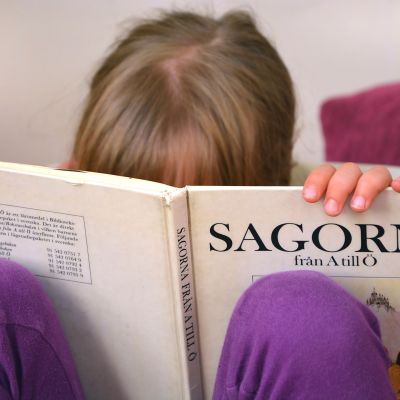 Barn läser bok med klassiska sagor.