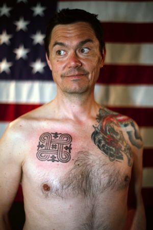 Tatuoitu mies taustalla Amerikan lippu