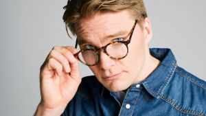 Tommi (Leo Honkonen) Tommi (Leo Honkonen) katsoo kameraan lasiensa takaa.