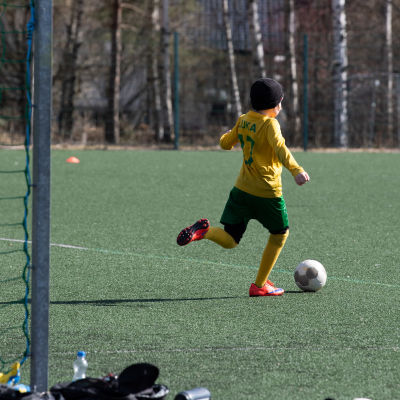 Lapset pelaavat jalkapalloa Matinkylän urheilupuistossa.