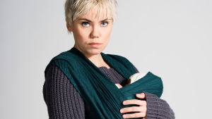 Ulla (Sara Melleri) Ulla (Sara Melleri) seisoo vauva kantoliinassa.