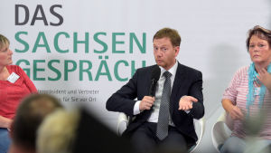 Sachsens regeringschef Michael Kretschmer diskuterade med torsdagskvällens demonstranter. Michael Kretschmer sitter i en panel om talar i en mikrofon.