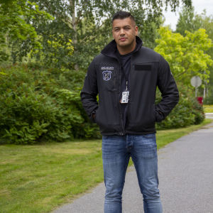 En krog utan fulla människor skulle rätt snabbt bli tom. En man iklädd en jacka som det står "security" på. I bakgrunden syns träd med gröna löv.